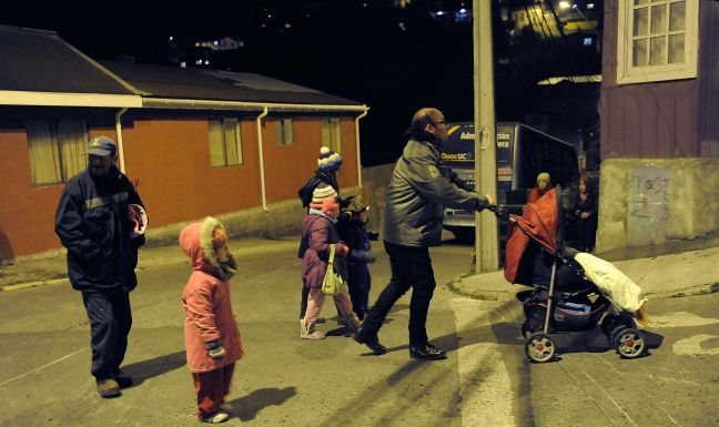 Residents walk to higher ground after a Tsunami alarm at Talcahuano city